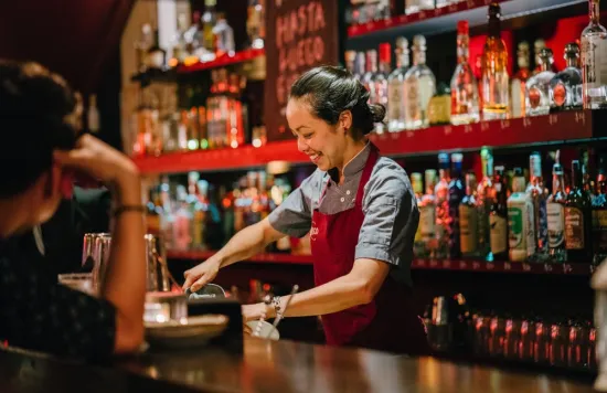 Bartender preparing drinks behind bar
