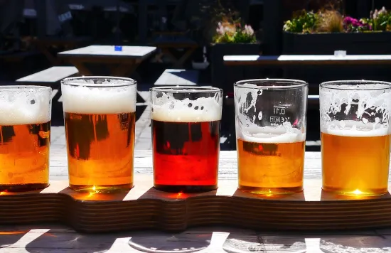 Different beers on a wooden tray.