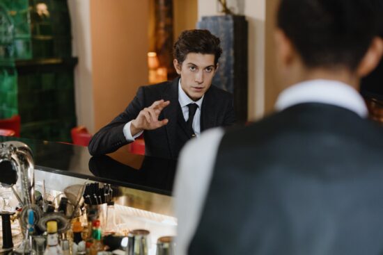 Bartender and a man speaking across a bar counter