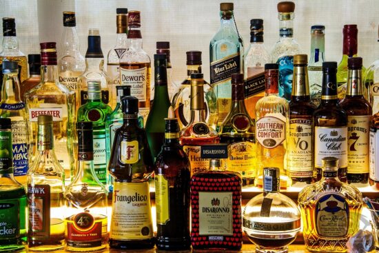 Assorted liquor bottles arranged together on a bar shelf