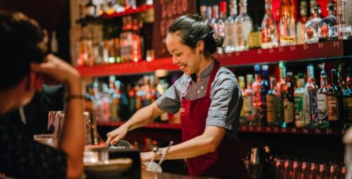 female bartender smiling while working