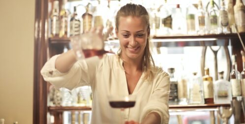 smiling waitress pours drink