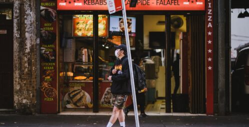 passerby waits at bus station